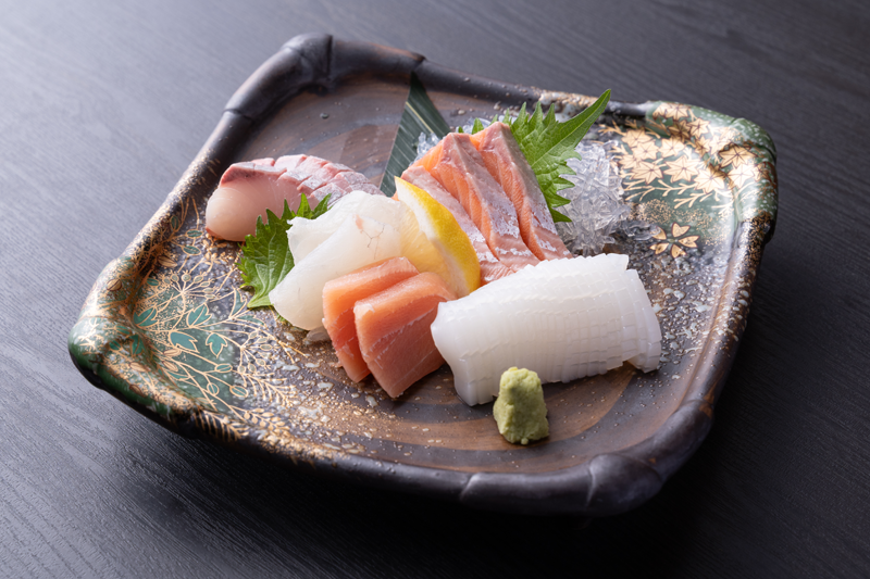 器に盛り付けた数種類の刺身と大葉